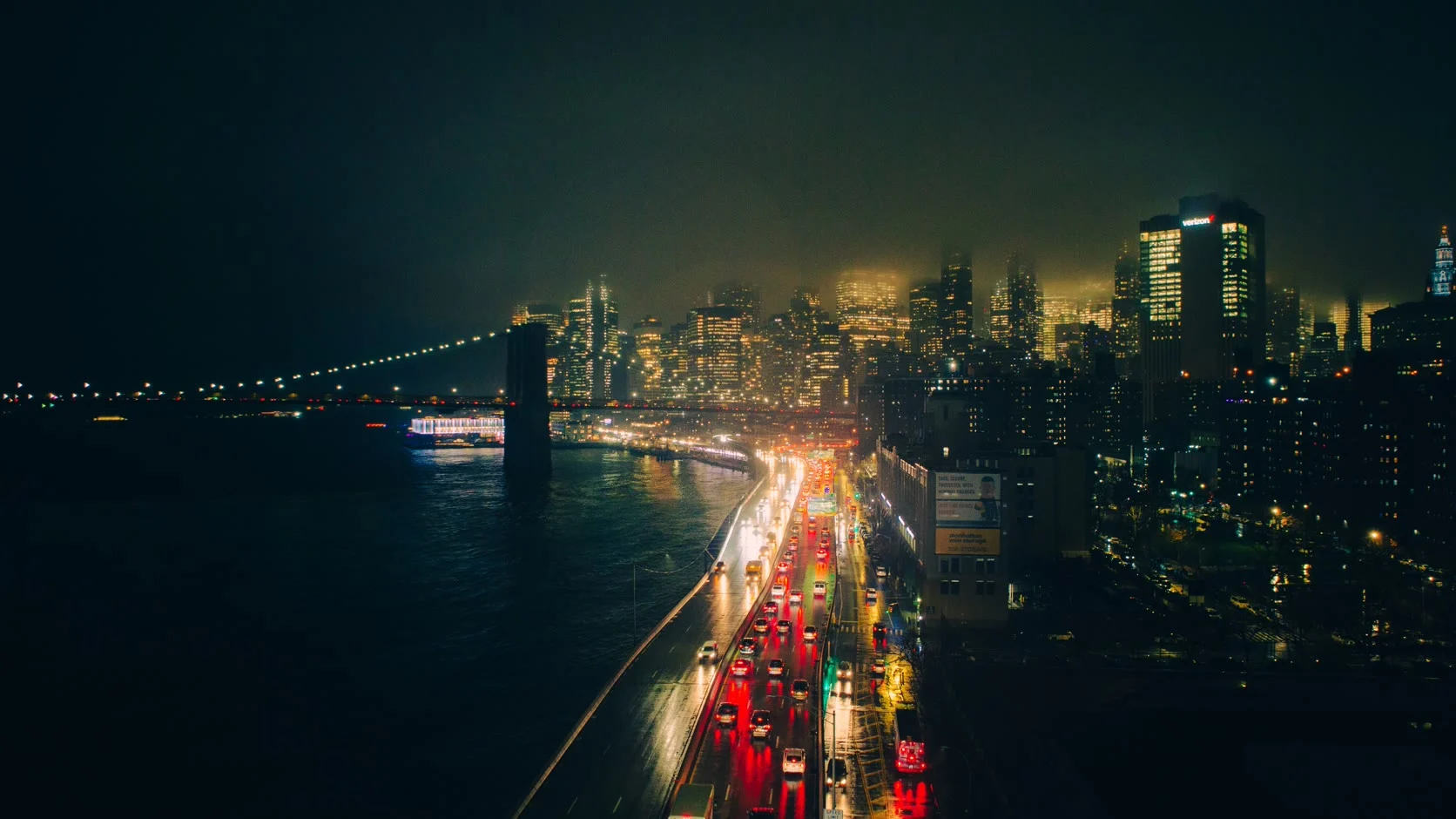 The Brooklyn Bridge and the lit Manhattan skyline across the East River at night